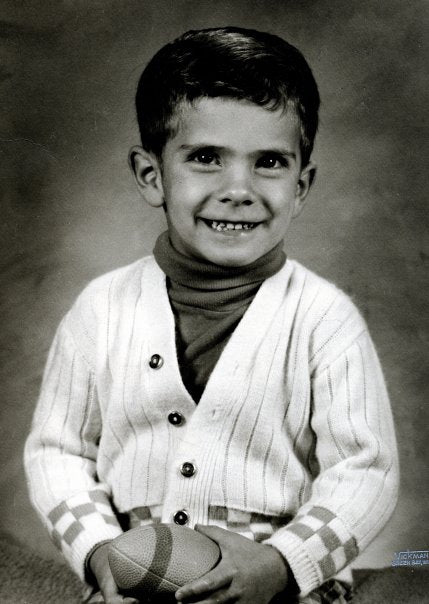 Nick as a child, holding a football in a family portrait